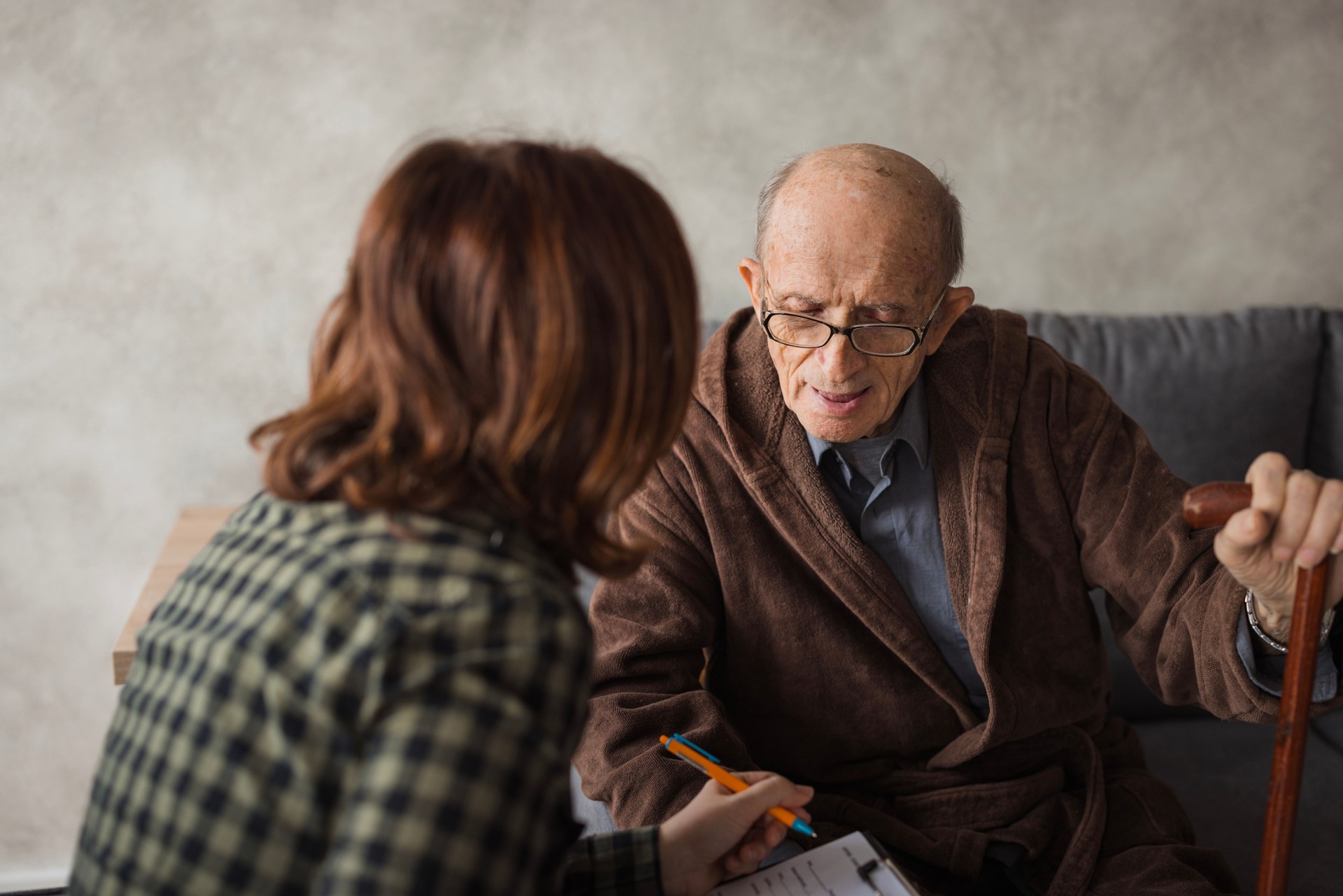 Senior man assisting a care giver at nursing home with his medical documentation